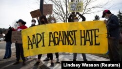 Người biểu tình giăng biểu ngữ với khẩu hiệu "Cộng đồng AAPI chống Hận thù Chủng tộc" tại một cuộc tuần hành để phản đối các tội ác vì hận thù người gốc Á tại Newcastle, Washington, Ngày 17/3/2021. (REUTERS/Lindsey Wasson)
