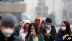 Người dân phải đeo khẩu trang để tránh khói bụi trên đường phố ở Bắc Kinh, Trung Quốc, ngày 8/12/2015.