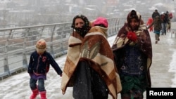 Người tị nạn Syria đi bộ trong thời tiết giá buốt ở Istanbul.