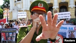 Công an chặn các nhiếp ảnh gia chụp ảnh trong một cuộc biểu tình chống Trung Quốc diễn ra trước Nhà hát lớn ở Hà Nội vào ngày 22 tháng 7 năm 2012.