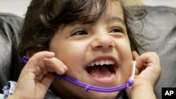 Bé gái cười trong khi được kiểm tra thính giác. (Ảnh tư liệu)