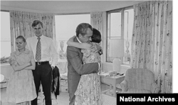 (ARŞİV) Eski Başkan Richard Nixon, 9 Ağustos 1974'te istifa kararını açıkladıktan kısa süre sonra kızı Julie Nixon Eisenhower'a sarılıyor