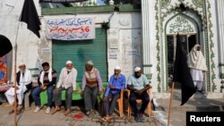 مسلمانوں کا ایک گروپ ایودھیا میں متنازع بابری مسجد کے باہر بیٹھا ہے۔ بھارت میں مسلمانوں کی تعداد کل آبادی کے 14 فی صد سے زیادہ ہے۔
