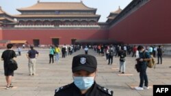 Một nhân viên canh gác ở Tử Cấm Thành ở Bắc Kinh trong lúc người dân Trung Quốc thực hiện dãn cách xã hội. Một báo cáo tình báo của Mỹ cho rằng chính quyền Bắc Kinh đã che giấu mức độ bùng phát của đại địch virus corona nhằm tích trữ vật tư y tế.