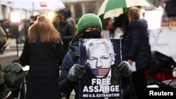 Người ủng hộ ông Julian Assange mang hình ảnh ông đứng trước toà án hình sự ở London, Anh, vào ngày 41/2021. 
