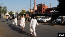 نئی دہلی کی جامع مسجد کے قریب سے چند مسلمان ماسک پہنے گزر رہے ہیں۔ بھارت میں کرونا کی وبا نے ہزاروں لوگوں سمیت کئی اہم شخصیات کو بھی نگل لیا ہے، جن میں احمد پٹیل اور شکیل سید بھی شامل ہیں۔ 