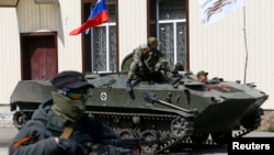 Các thành phần ly khai vũ trang và xe bọc thép treo quốc kỳ Nga lăn bánh vào thành phố Sloviansk của Ukraine, ngày 16/4/2014.