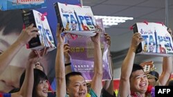 Khách du lịch Trung Quốc cầm các túi quà tặng khi họ tới sân bay Songshan ở trung tâm thành phố Đài Bắc, Đài Loan, ngày 28/6/2011