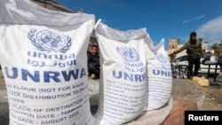  رفح میں لوگ اقوام متحدہ کے فلسطینی مہاجرین کے امدادی ادارے کی پہنچائی جانے والی امداد وصول کرنے کے منتظر ہیں ، فوٹو رائٹرز 7 مارچ 2024 