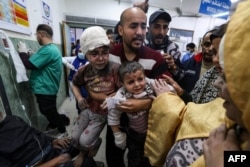 غزہ میں اسرائیلی بمباری سے زخمی ہونے والے بچوں کو ایک شخص رفح کے النجار ہسپتال لا رہا ہے ، فوٹو اے ایف پی 24 مارچ 2024