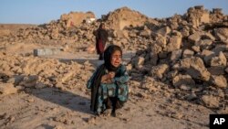  ہرات کے ڈسٹرکٹ زندان جان میں ایک لڑکی اپنے تباہ شدہ گھر کے سامنے رو رہی ہے ، فوٹو اے پی 15 جنوری 2024