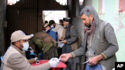  افغان شہری صوبے لوگار میں ورلڈ فوڈ پروگرام کی جانب سے خوراک کے راشن وصول کر رہے ہیں۔ 