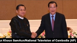کمبوڈیا کے وزیر اعظم ہون سان میانمار کی ریاست کی انتظامی کونسل کے سربراہ، سینئر جنرل من آنگ ہینگ (بائیں جانب) سے ہاتھ ملاتے ہوئے۔ 7 جنوری، 2022ء (فائل فوٹو)