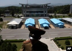 جنوبی اور شمالی کوریا کے درمیان واقع سیاحتی مقام پین مونجوم میں شمالی کوریا کے فوجی تعینات ہیِں، جبکہ جنوبی کوریا کی حدود میں واقع بلڈنگ کمپلیکس کی عمارت نظر آہی ہے۔ فوٹو اے پی