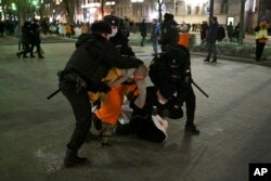 ماسکو میں پولیس مظاہرے میں شامل ایک شخص کو گرفتار کر رہی ہے۔ 24 فروری 2022