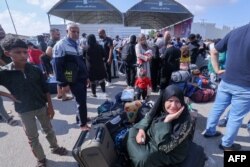 رفح گزرگاہ پر فلسطینی جن میں سے کچھ کے پاس غیر ملکی پاسپورٹ ہیں ، مصر جانے کے انتظار میں ہیں ، فوٹو اے ایف پی