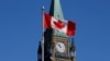 کینیڈا کے دارالحکومت اوٹاوا میں پارلیمنٹ ہل پر پیس ٹاور کے سامنے ملک کا پرچم لہرا رہا ہے/ (فائل فوٹو)