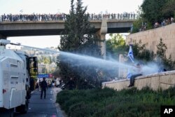 اسرائیلی پولیس یروشلم میں ایک مظاہرے کو منتشر کرنے کے لئے پانی کی بوچھاڑ استعمال کر رہی ہے، فوٹو اے پی ،24 جولائی 2023