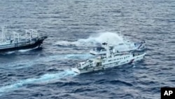 Tàu Trung Quốc phun nước vào tàu Philippines ở gần Bãi Cỏ Mây trên Biển Đông hồi tháng 10/2023 (Philippine Coast Guard via AP).